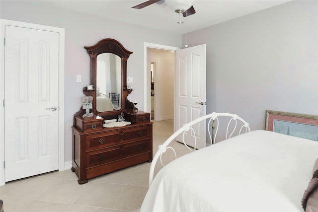 bedroom featuring light tile patterned floors, a ceiling fan, and baseboards