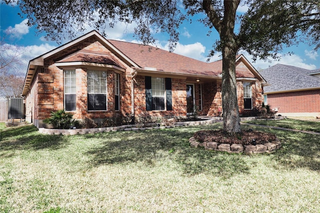 ranch-style home with a front yard, brick siding, and a shingled roof