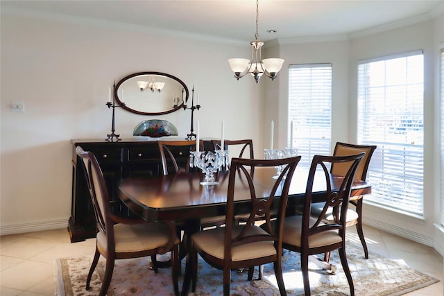 dining space with a chandelier, ornamental molding, light tile patterned floors, and baseboards