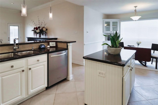 kitchen with dishwasher, a sink, dark countertops, and healthy amount of natural light