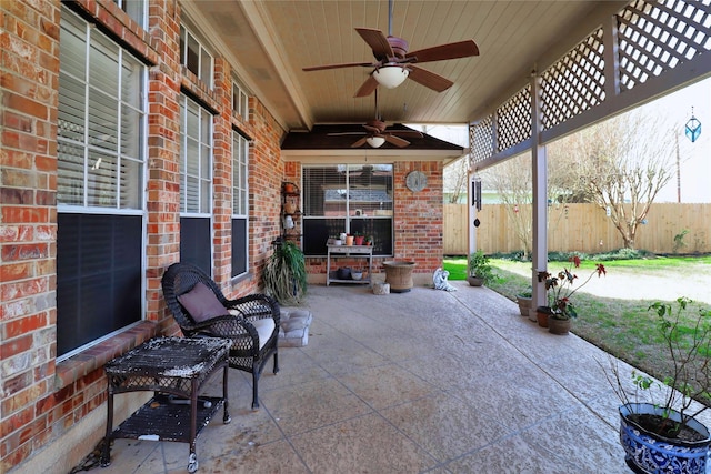 view of patio featuring ceiling fan and fence