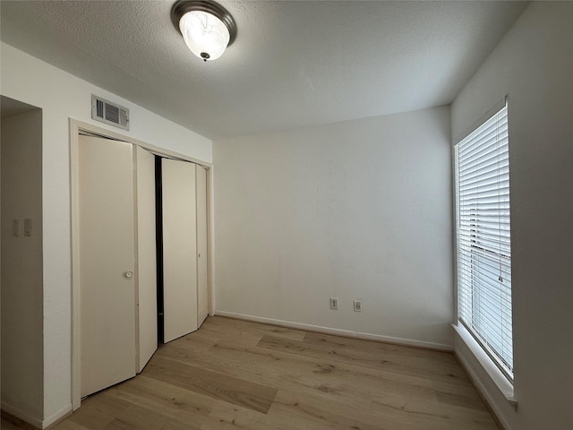 5711 Sugar Hill Dr Unit 62, Houston, TX 77057 - unfurnished bedroom with visible vents, light wood-style floors, and multiple windows