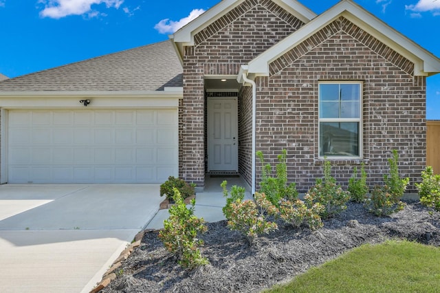 ranch-style house with brick siding, roof with shingles, a garage, and concrete driveway