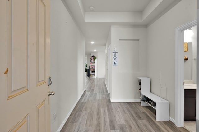 corridor with recessed lighting, light wood finished floors, and baseboards
