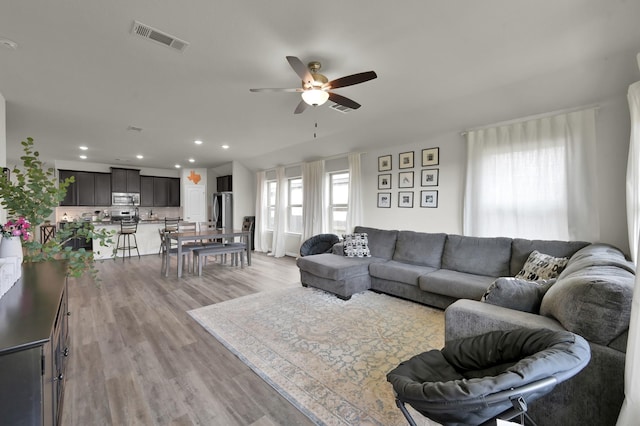 living area featuring light wood-style flooring, visible vents, recessed lighting, and ceiling fan