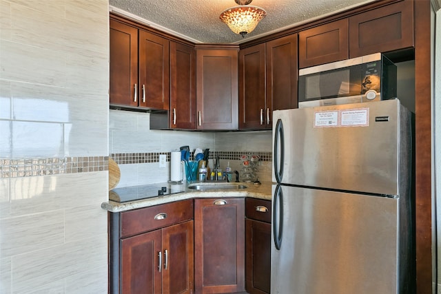 6102 Seawall Blvd Unit 155, Galveston, TX 77551 - kitchen featuring light stone counters, a sink, backsplash, and appliances with stainless steel finishes
