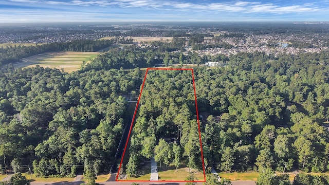 drone / aerial view featuring a wooded view