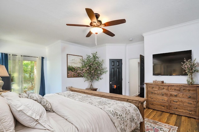 bedroom featuring wood finished floors, a ceiling fan, and ornamental molding