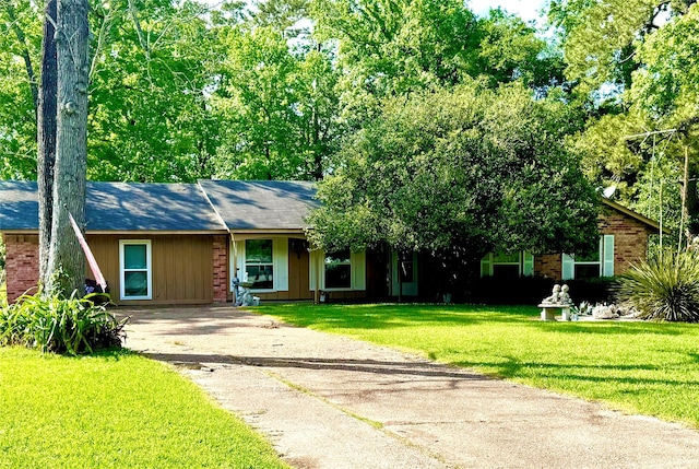 view of front of home featuring brick siding, a front lawn, and aphalt driveway