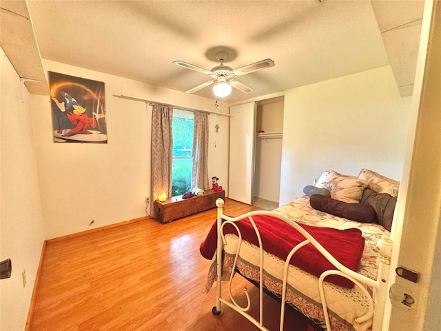 bedroom with wood finished floors, a textured ceiling, and a ceiling fan