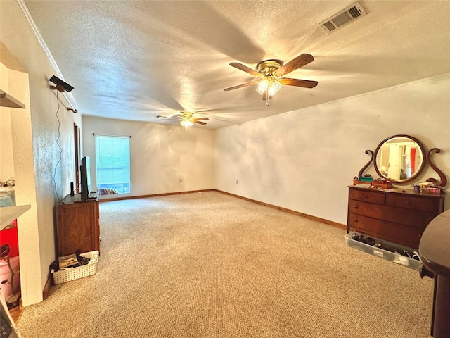 interior space with visible vents, a ceiling fan, baseboards, a textured ceiling, and carpet flooring