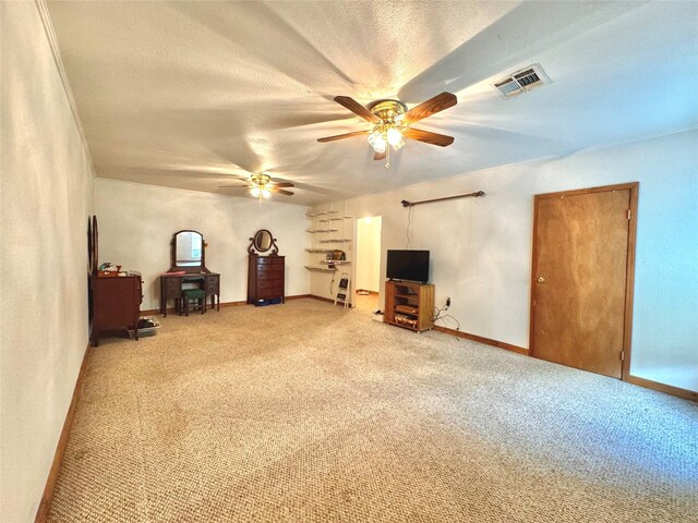 interior space with a textured ceiling, baseboards, visible vents, ceiling fan, and carpet floors