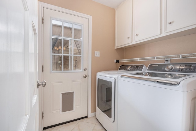 washroom featuring light tile patterned floors, cabinet space, and washer and clothes dryer