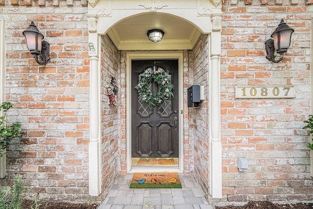 doorway to property featuring brick siding