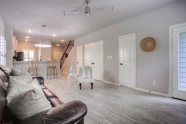 279 Capetown, Conroe, TX 77356 - living room with stairway, light wood finished floors, a ceiling fan, and baseboards