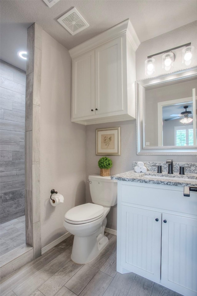 279 Capetown, Conroe, TX 77356 - full bath with toilet, wood finished floors, vanity, a tile shower, and baseboards