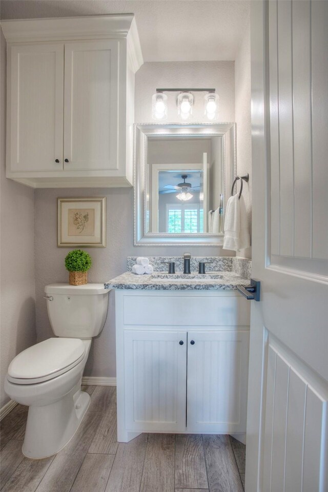 279 Capetown, Conroe, TX 77356 - half bath featuring wood finished floors, toilet, vanity, baseboards, and a ceiling fan