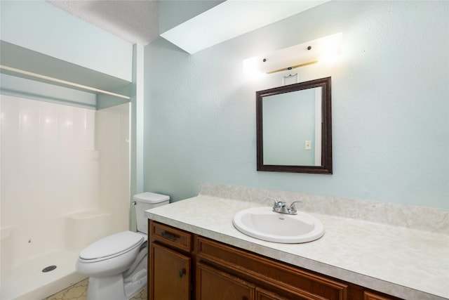 bathroom with a shower stall, toilet, and vanity