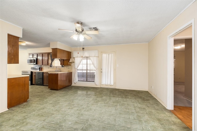 interior space with a sink, a textured ceiling, light floors, ceiling fan, and visible vents