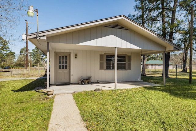 bungalow featuring a front lawn, fence, and a patio area