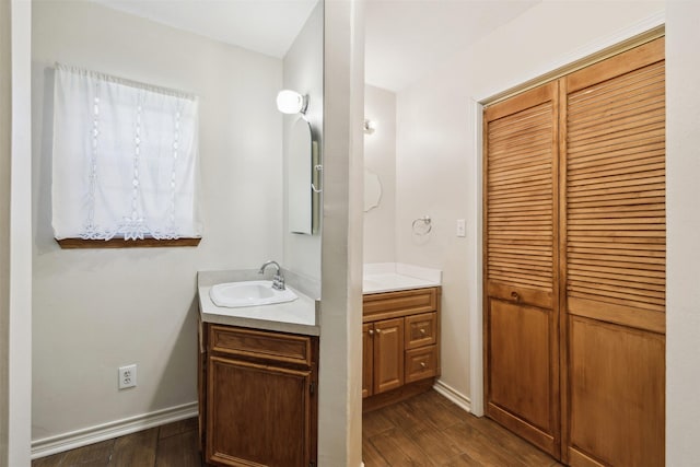 5233 N US Highway 183, Gonzales, TX 78629 - bathroom featuring two vanities, wood finished floors, baseboards, and a sink