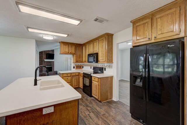 27 Westwood Dr W, Trinity, TX 75862 - kitchen featuring black appliances, a sink, a brick fireplace, dark wood-style floors, and tasteful backsplash