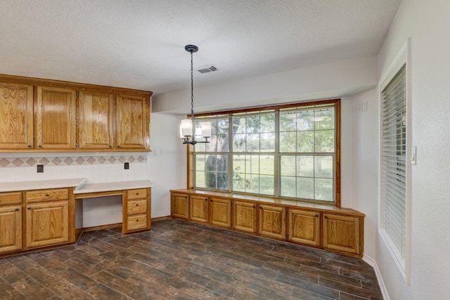 27 Westwood Dr W, Trinity, TX 75862 - kitchen with brown cabinetry, dark wood-style floors, pendant lighting, and light countertops