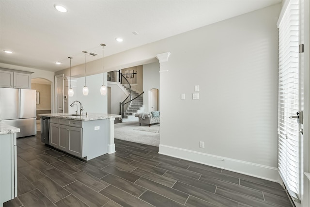 12107 Allington Cove Ln, Humble, TX 77346 - kitchen featuring arched walkways, appliances with stainless steel finishes, gray cabinetry, and recessed lighting