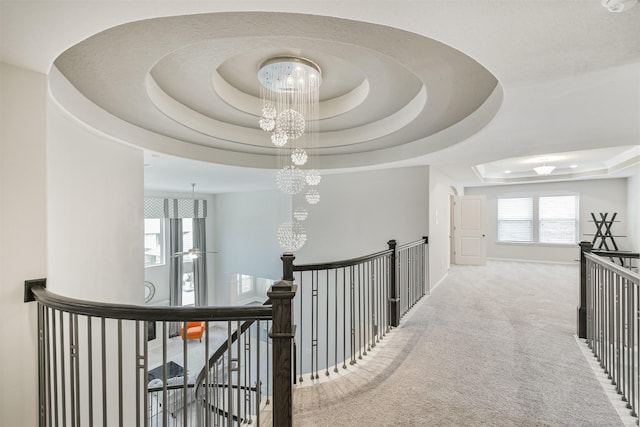12107 Allington Cove Ln, Humble, TX 77346 - hall featuring an inviting chandelier, a raised ceiling, an upstairs landing, carpet floors, and baseboards