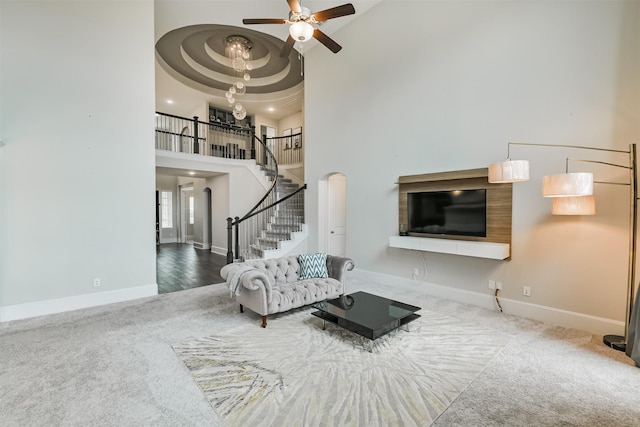 12107 Allington Cove Ln, Humble, TX 77346 - living room featuring ceiling fan, a high ceiling, stairs, and baseboards