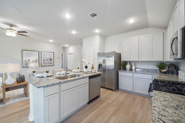 804 Timmons Ln, Dayton, TX 77535 - kitchen featuring light wood finished floors, stainless steel appliances, visible vents, a sink, and a center island with sink