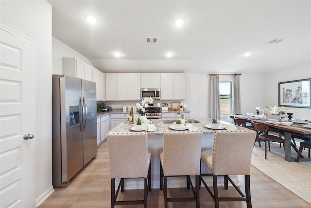 804 Timmons Ln, Dayton, TX 77535 - kitchen with a kitchen breakfast bar, visible vents, a sink, and appliances with stainless steel finishes