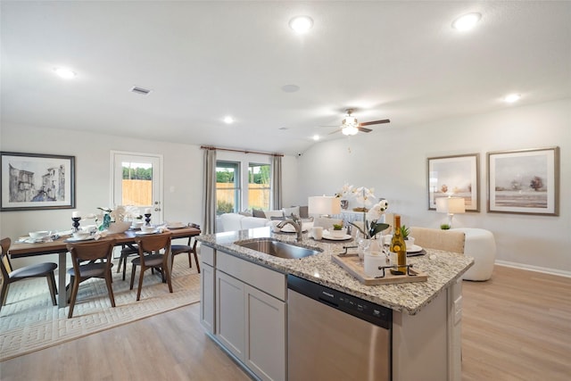 804 Timmons Ln, Dayton, TX 77535 - kitchen with stainless steel dishwasher, open floor plan, a sink, and light wood-type flooring