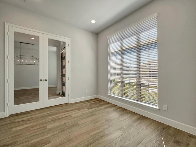 unfurnished room featuring recessed lighting, baseboards, french doors, and wood finished floors