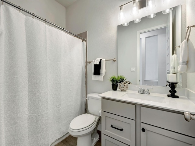 bathroom with vanity, toilet, and wood finished floors