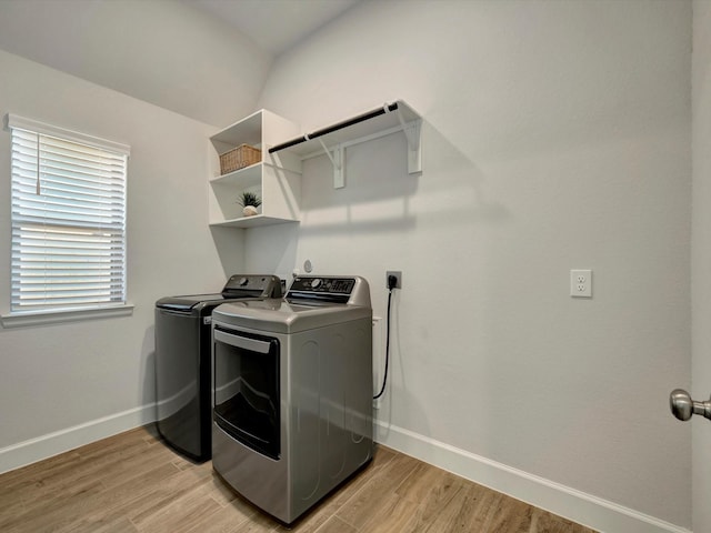 washroom with baseboards, laundry area, light wood-type flooring, and washer and dryer