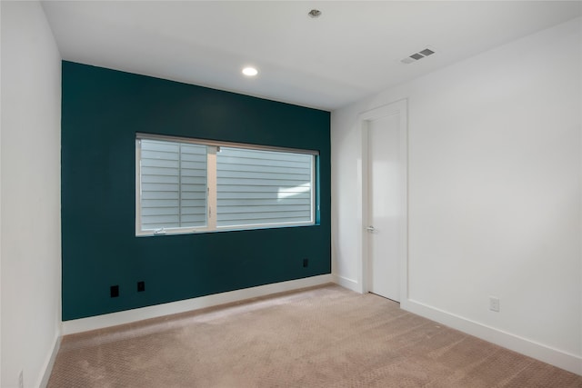 spare room with recessed lighting, baseboards, visible vents, and carpet