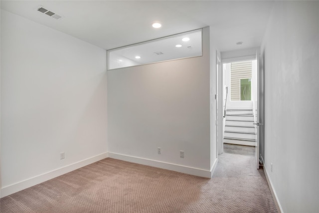 empty room featuring baseboards, visible vents, carpet floors, and recessed lighting