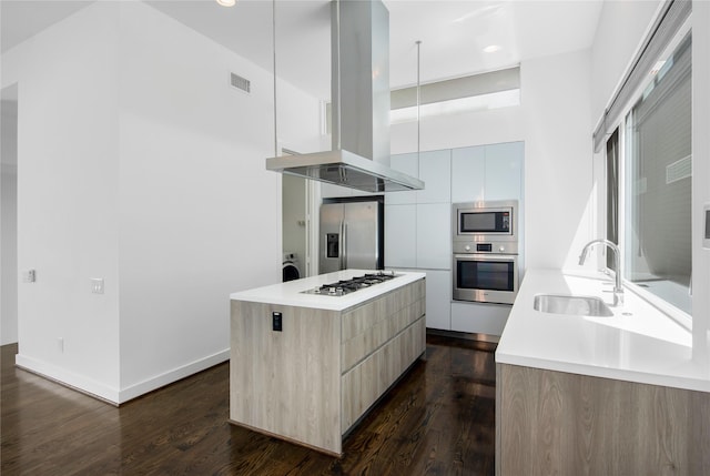 kitchen with island exhaust hood, visible vents, a sink, modern cabinets, and appliances with stainless steel finishes
