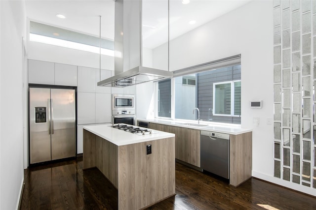 kitchen with modern cabinets, stainless steel appliances, a kitchen island, and a sink