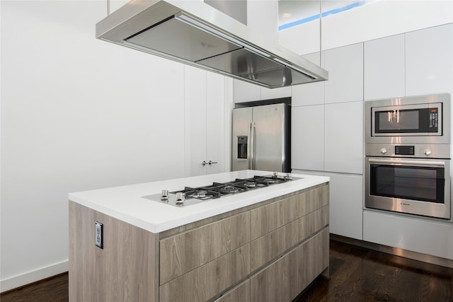 kitchen featuring dark wood-style flooring, modern cabinets, range hood, a kitchen island, and appliances with stainless steel finishes