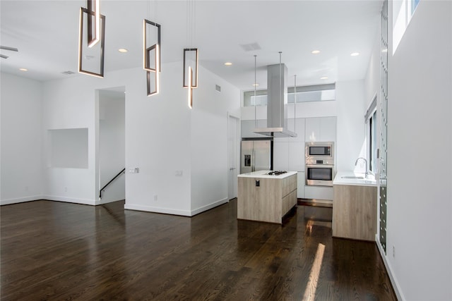 unfurnished living room featuring recessed lighting, a towering ceiling, a sink, baseboards, and dark wood-style flooring