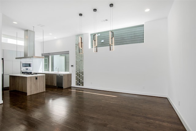 interior space featuring island exhaust hood, stainless steel appliances, light countertops, modern cabinets, and a kitchen island