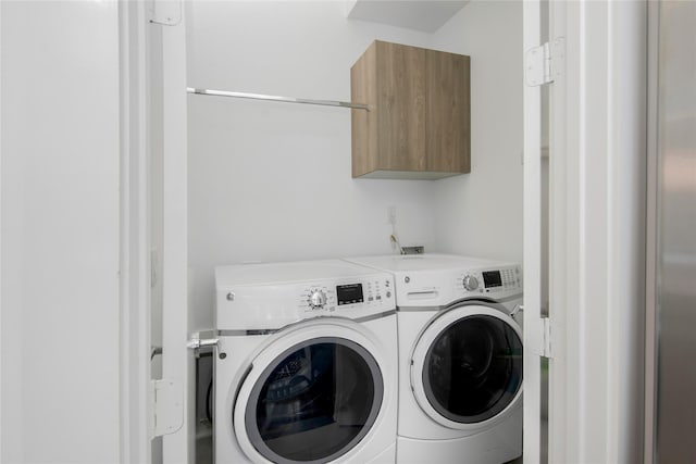 washroom with separate washer and dryer and cabinet space