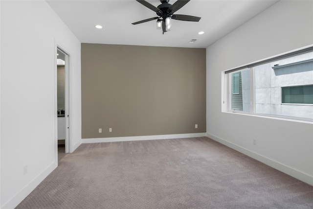 empty room featuring recessed lighting, visible vents, a ceiling fan, baseboards, and carpet flooring
