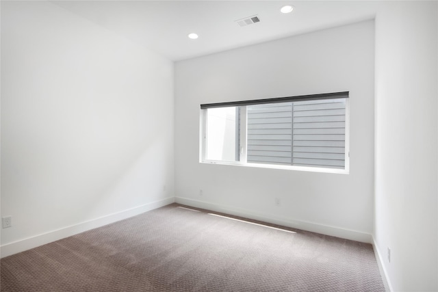 spare room featuring recessed lighting, carpet, visible vents, and baseboards
