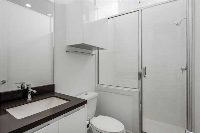 bathroom with vanity, toilet, and a stall shower