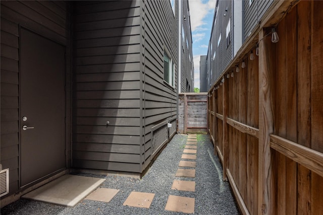 view of side of home with uncovered parking and fence