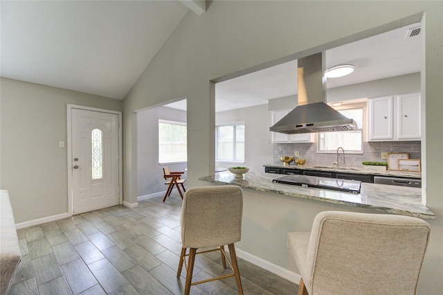 17434 Jolly Boat Dr, Crosby, TX 77532 - kitchen with island exhaust hood, a sink, stovetop, light stone countertops, and lofted ceiling