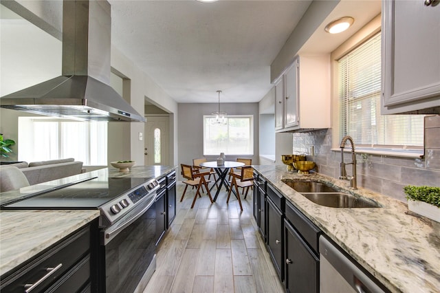 17434 Jolly Boat Dr, Crosby, TX 77532 - kitchen with ventilation hood, stainless steel appliances, a sink, light wood-style floors, and backsplash